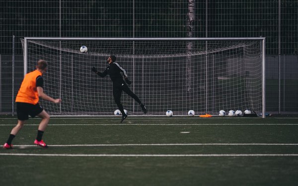 How can football goalkeepers improve their decision-making skills during penalty shootouts?